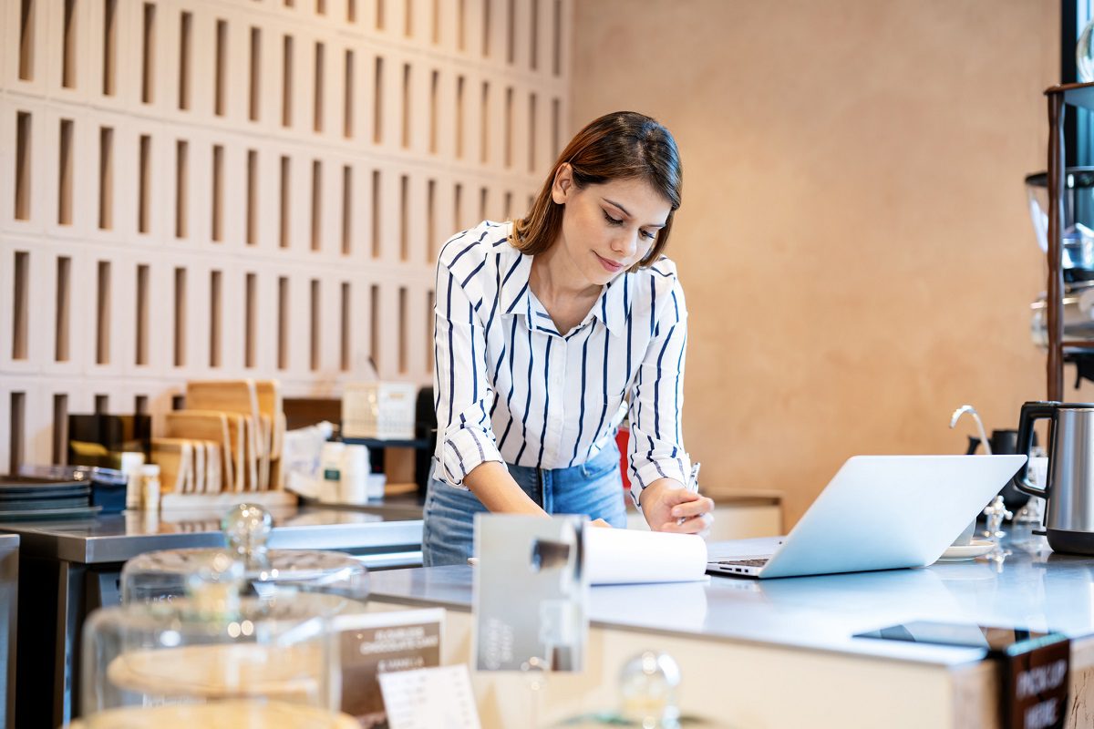 A woman stands at a counter in a modern cafe