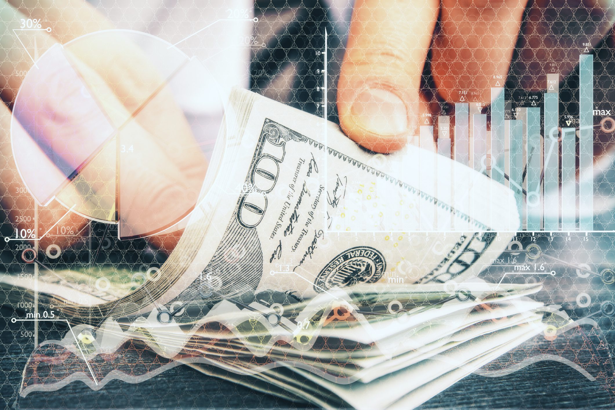 Hand holding a stack of US hundred-dollar bills