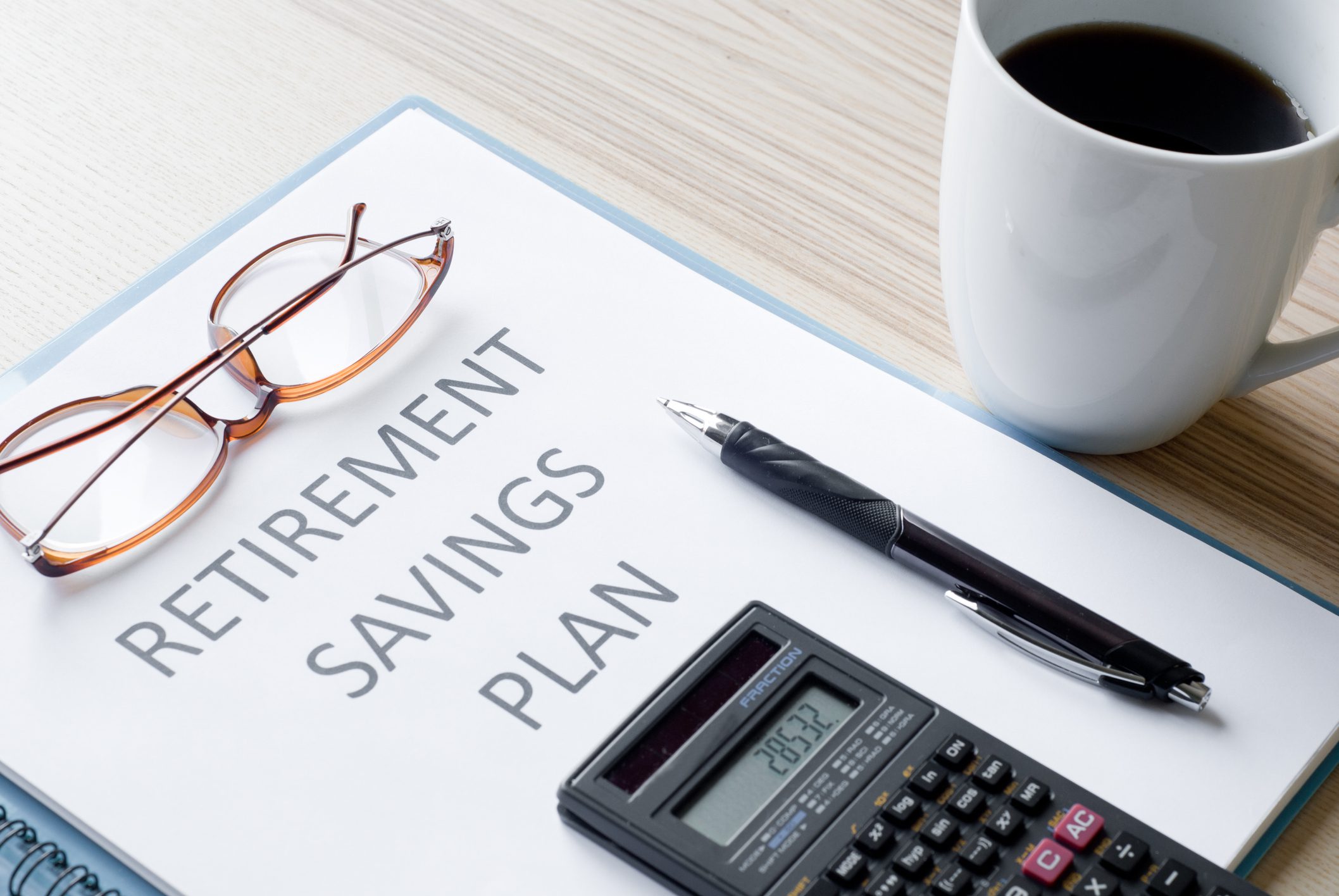 A document labeled Retirement Savings Plan on a desk with eyeglasses